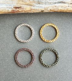 This listing is for 4 or 10 pcs of these Gold 19mm Hammered Rings by Tierra Cast. These lovely rings feature a hammered texture on the front and back and a shiny gold-plated finish. They are solid, sturdy, closed rings. These high-quality components are made of electroplated pewter here in the US and are 100% lead-free. Each ring measures approximately 19mm wide x 2mm thick with an 14.3mm inner diameter. These pieces are extremely lightweight, weighing approximately 1.4 grams each. Please choose Metal Rings For Jewelry Making, Stackable Round Metal Midi Rings, Stackable Metal Midi Rings, Pewter Ring, Hammered Gold Ring, Hammered Silver Ring, Hammered Ring, Hammered Rings, Lovely Ring