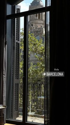 an open window with the view of a building in barcelona, spain on a sunny day