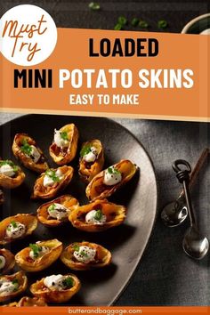 loaded mini potato skins on a black plate with spoons and utensils in the background