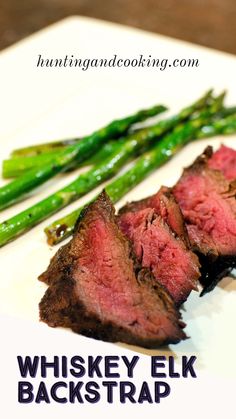 steak and asparagus on a white plate with the words whiskey elk backstrap