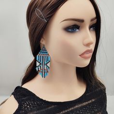 These midi fringe bohemian beaded earrings feature an intricate ethnic design with light blue and white as the dominant colors, complemented by subtle black, bronze, and gold accents. Crafted with precision using high-quality Japanese Delica beads, these earrings are not only lightweight but also showcase a beautiful boho-inspired pattern. The fringe adds a touch of movement, making them a versatile accessory for both casual and formal outfits. The soft color palette and detailed craftsmanship m Blue Fringed Beaded Earrings For Festival, Bohemian Turquoise Tassel Earrings With Colorful Beads, Blue Fringe Earrings For Festivals, Blue Tassel Drop Earrings For Festival, Festival Turquoise Beaded Fringe Earrings, Blue Beaded Fringe Earrings For Festival, Blue Beaded Fringe Tassel Earrings For Festivals, Turquoise Beaded Tassel Earrings For Festival, Bohemian Turquoise Beaded Fringe Earrings