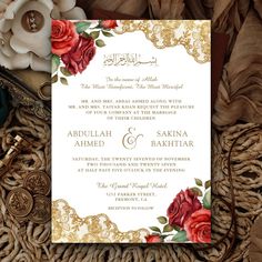 an ornate wedding card with red roses and gold trimmings on top of it