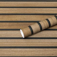 a roll of wood sitting on top of a wooden floor next to some black bars