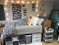 a dorm room with lights strung above the bed and various storage bins on the floor