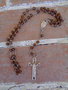 "This is a vintage rosary necklace with brown glass faceted beads. The necklace measures 18\" and slips over your head. It is a silver tone cross on end and a mother Mary in middle. Not marked, but I  believe it was made in Italy. Please don' t hesitate to ask questions. happy collecting!" Rosary With Faceted Beads And Crucifix, Brown Cross Rosary In Spiritual Style, Brown Cross-shaped Spiritual Rosary, Brown Cross Shaped Spiritual Rosary, Brown Spiritual Rosary With Cross, Brown Rosary With 8mm Beads And Cross Shape, Brown Beaded Rosary With Cross Shape, Brown Rosary With 8mm Beads, Brown Beaded Cross-shaped Rosary