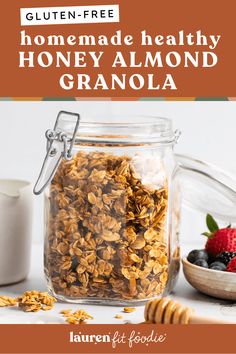 homemade healthy granola recipe in a jar with berries and honey on the side, text reads gluten - free homemade healthy honey almond granola