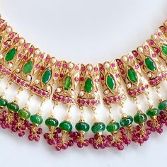 Featured is an emerald dominated necklace set in 22k gold. The stones in setting as well as hangings are precious rubies, emeralds and pearls. The necklace weighs 63.6 gms including 14.9 gms in the hanging rubies, emeralds and pearl beads. The earrings weigh 16.25 gms including 2.8 gms in the hanging rubies, emeralds and pearl beads. Yellow Gold Emerald Necklace For Festivals, 22k Gold Multi-stone Temple Jewelry Necklace, 22k Gold Multi-stone Temple Necklace, 22k Gold Green Temple Necklace For Celebration, 22k Gold Green Temple Necklace For Festive Occasions, Green 22k Gold Temple Necklace For Celebration, Green 22k Gold Temple Necklace For Festive Occasion, Festive 22k Gold Green Temple Necklace, Celebration Green 22k Gold Temple Necklace