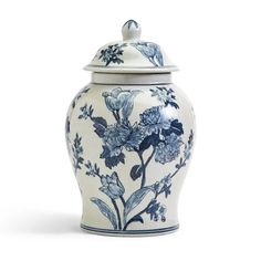 a blue and white vase with flowers on the lid is shown against a white background