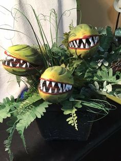 some plants with fake teeth on them in a pot