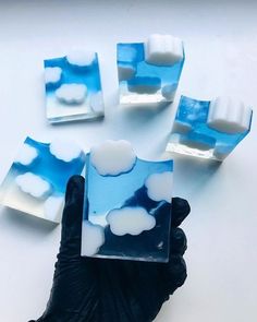 several pieces of blue and white soap sitting on top of each other in black gloves