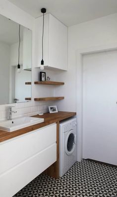 a washer and dryer in a room with black and white tile flooring