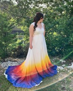 a woman in a long dress standing on the grass