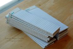 stacks of folded papers sitting on top of a wooden table