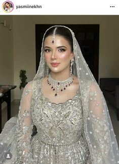 a woman in a wedding dress wearing a tiara and veil with jewels on her head