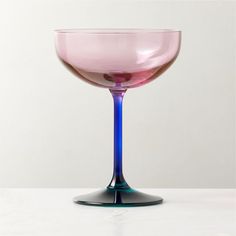 a pink and blue glass sitting on top of a table