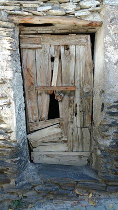 an old wooden door is open on a stone building