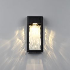 a light that is on the side of a wall with some lights coming from it