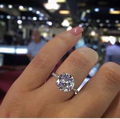 a woman's hand with a ring on it and a diamond in the middle