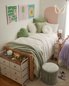 a bedroom with a bed, dresser and two pictures on the wall