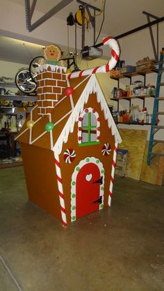 a cardboard gingerbread house with candy canes on it's roof in a garage