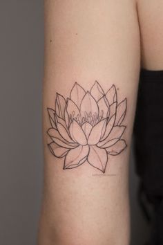 a woman's arm with a black and white flower tattoo on the left side