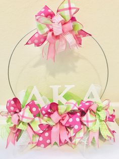 a pink, green and white polka dot wreath with the letter k on it's side