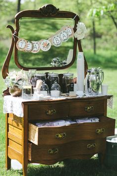 an old dresser with baby's first year decorations on it and flowers in front of the mirror