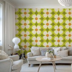 a living room filled with furniture next to a wall covered in green and white circles