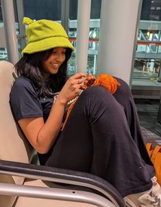 a woman wearing a yellow hat is sitting on a bus