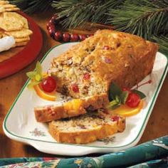 a loaf of bread on a plate with fruit and crackers