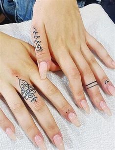 two people with matching tattoos on their fingers