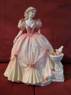 a ceramic figurine of a woman in a pink dress