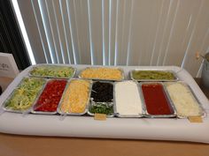 a table topped with trays filled with different types of food