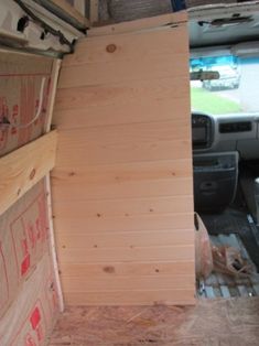 the inside of a van with wood boards stacked on top of each other in front of it