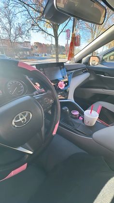 the interior of a car with pink trim and steering wheel, dash board, and dashboard