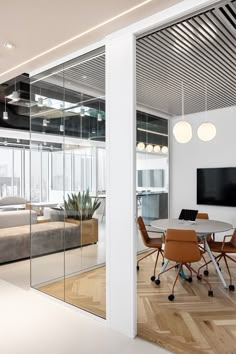 an office with glass walls and wooden floors