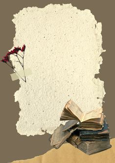 an old book and some red flowers are on top of the torn paper that has been placed in front of it