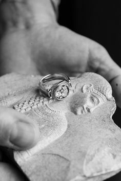 a person holding a ring on top of a small piece of paper in their hand