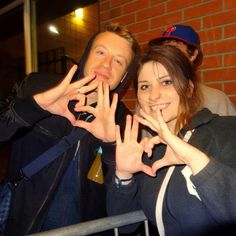 two people making the v sign with their hands