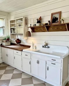 a kitchen with white cabinets and black and white checkerboard flooring on the walls