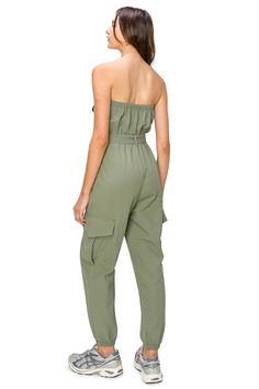 100% Nylon Feature: The cargo jumpsuit, featuring a tube top, zipper-front closures, jogger leg, and buttoned chest flap pockets, is designed with both style and functionality in mind. Its self-tie waist and side-leg cargo pockets add to its practicality while offering a laid-back yet polished look. This piece is a standout addition to our CALI1850 Collection, embodying cool California vibes. Versatile Style: Its versatility is unmatched; pair it with a zip-up hoodie, cardigans, and sneakers for Cargo Jumpsuit, California Vibe, Belted Jumpsuit, Belt Jumpsuit, Sporty Look, Versatile Style, Polished Look, S Models, Tube Top