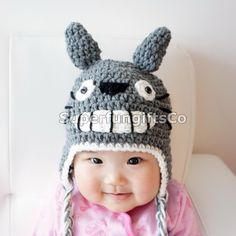 a baby wearing a crocheted hat with ears and eyes on it's head