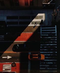 the shadow of a person standing on top of a ramp next to a parking lot