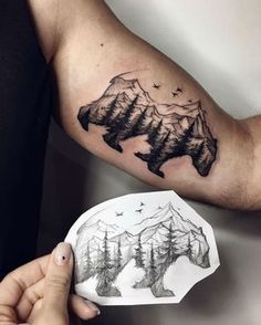 a man's arm with mountains and trees tattoo on the left side of his arm