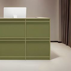 a green desk with a laptop on it in front of a curtained wall and window