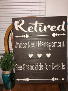 a wooden sign that says retired under new management see grandkids for details next to a potted plant