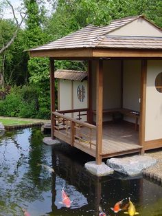 a gazebo sitting on top of a wooden platform next to a body of water