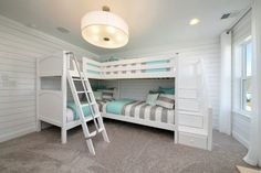 a bedroom with bunk beds and ladders in it