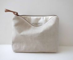 a small white pouch with a wooden handle