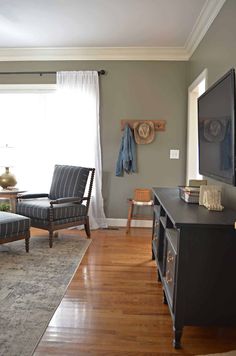 a living room filled with furniture and a flat screen tv on top of a wooden table